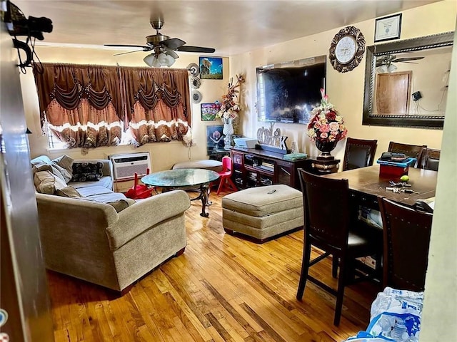 living room with ceiling fan, wood-type flooring, and a wall unit AC