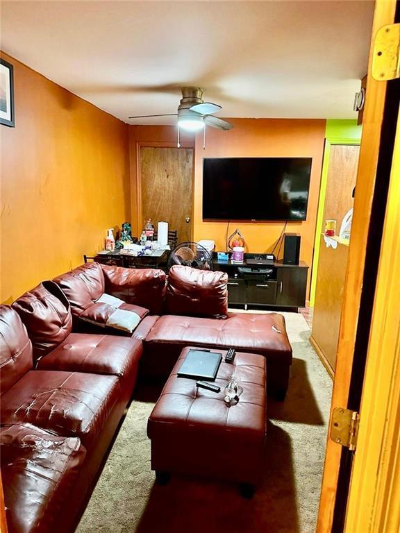living room featuring carpet floors and ceiling fan