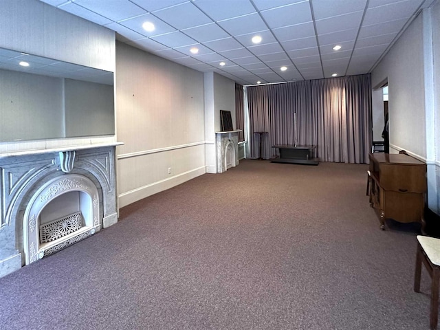 unfurnished living room with carpet floors and a paneled ceiling