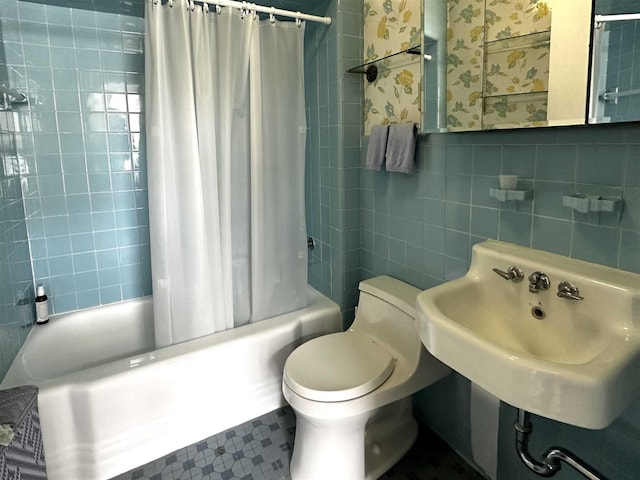 full bathroom with shower / tub combo with curtain, sink, toilet, and tile walls