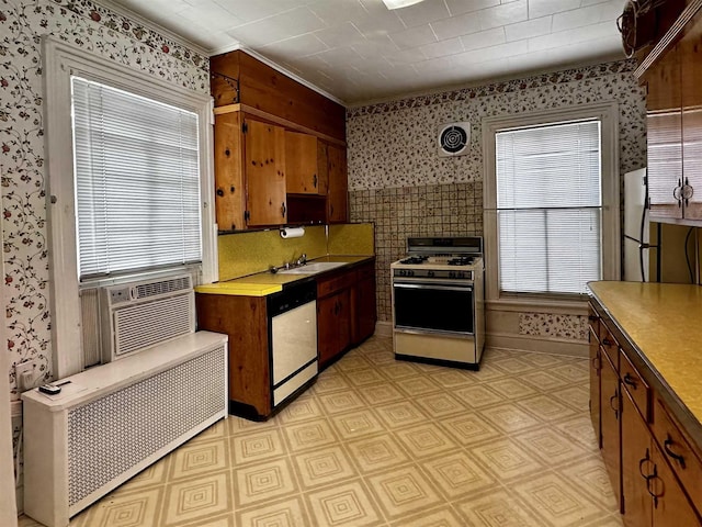 kitchen with radiator, sink, cooling unit, stainless steel dishwasher, and white gas stove