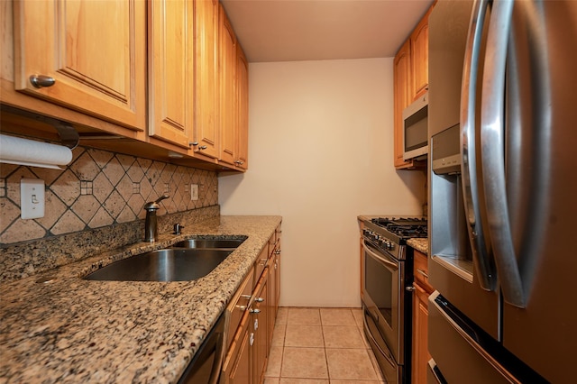 kitchen with sink, light stone counters, light tile patterned floors, stainless steel appliances, and decorative backsplash