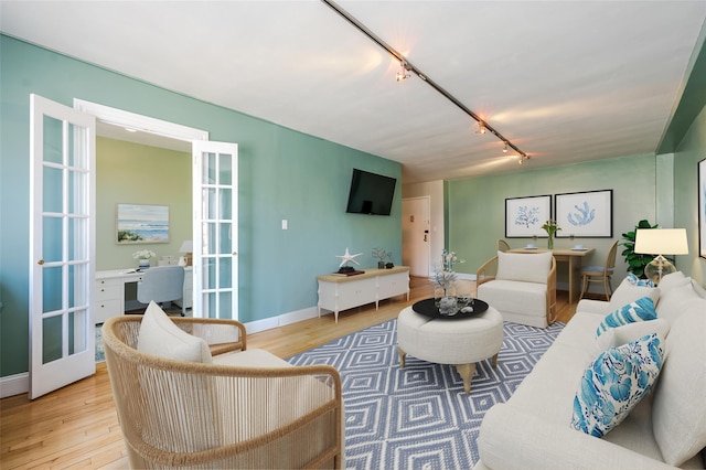 living room with french doors, track lighting, and light hardwood / wood-style floors