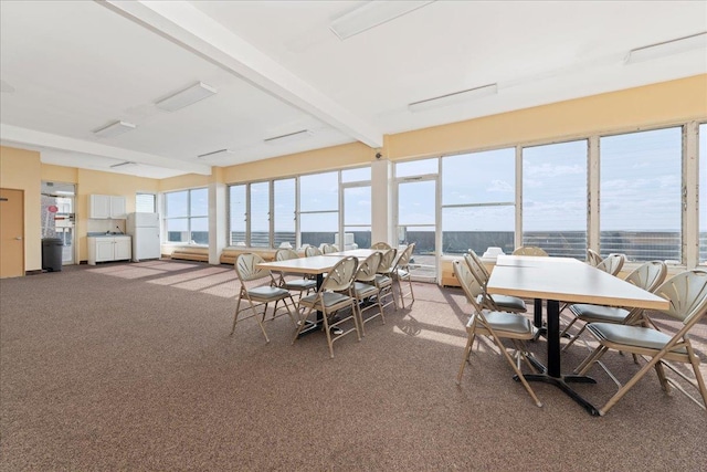 sunroom / solarium featuring beam ceiling