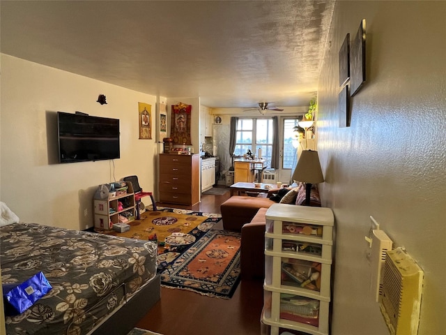 bedroom with hardwood / wood-style flooring, a wall unit AC, and a textured ceiling