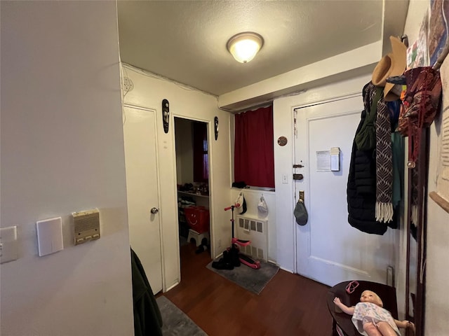 foyer entrance with radiator heating unit and dark hardwood / wood-style floors