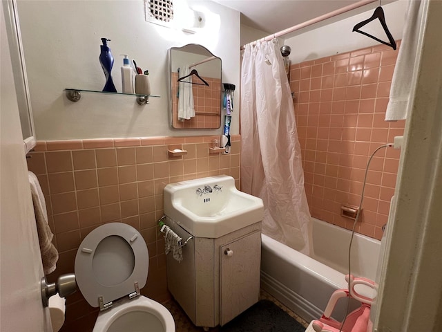 full bathroom with vanity, tile walls, shower / bathtub combination with curtain, and toilet