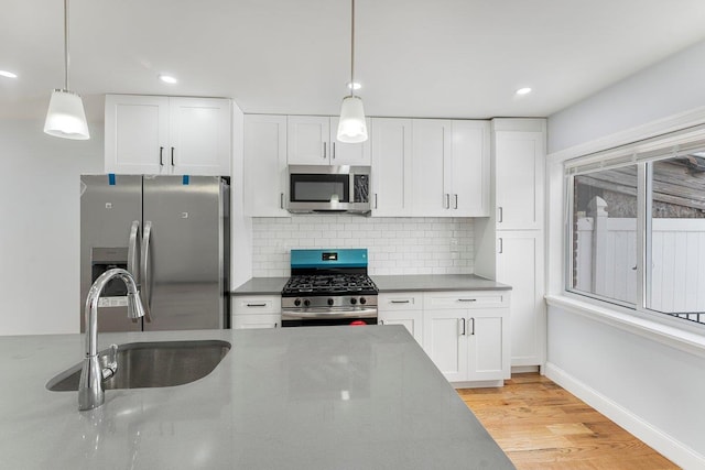 kitchen with light hardwood / wood-style floors, sink, white cabinetry, and stainless steel appliances