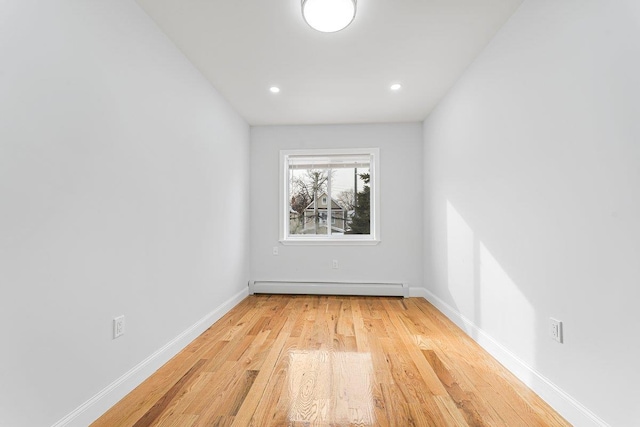 unfurnished room featuring light hardwood / wood-style floors and baseboard heating