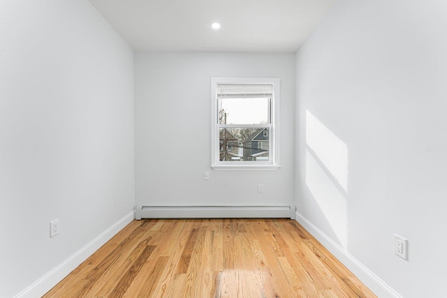 empty room with a baseboard radiator and light wood-type flooring