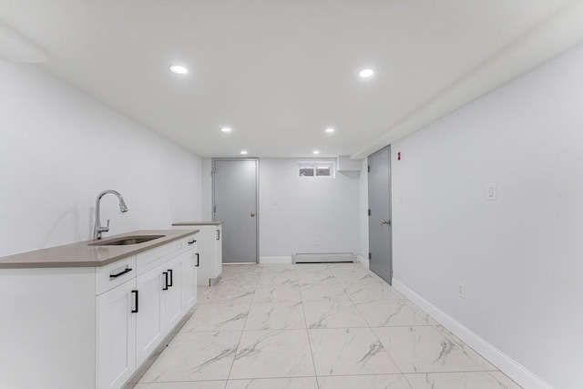 kitchen featuring sink, a baseboard radiator, and white cabinetry