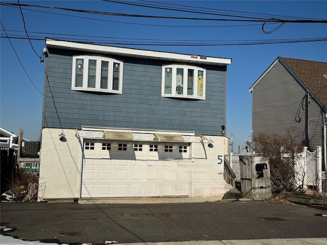 view of front of home with central AC unit and a garage