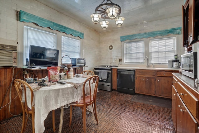 kitchen with appliances with stainless steel finishes, decorative light fixtures, sink, dark tile patterned flooring, and an inviting chandelier