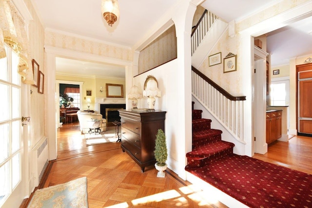 foyer entrance featuring crown molding and light parquet flooring