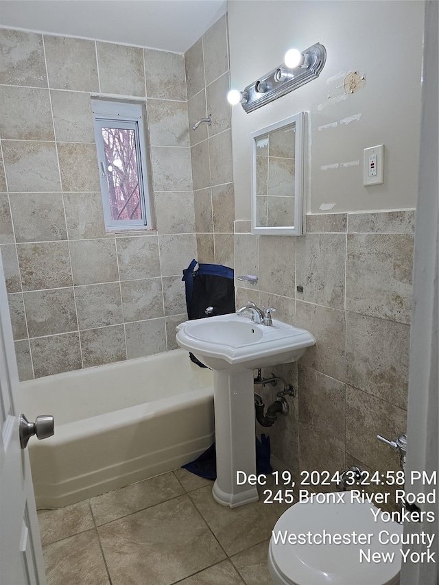 bathroom with  shower combination, toilet, tile walls, and tile patterned flooring