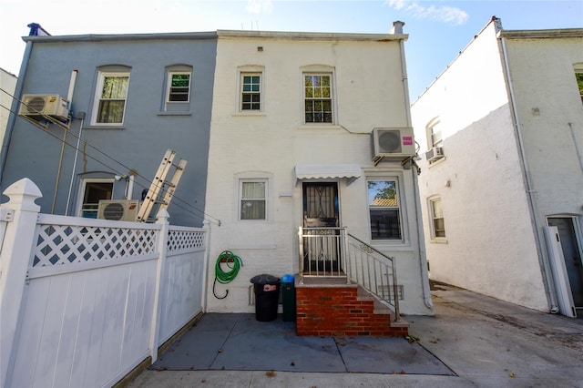 rear view of property featuring a wall mounted air conditioner, a patio, and ac unit