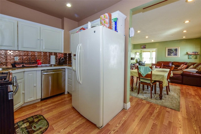 kitchen featuring white cabinetry, stainless steel appliances, light wood-type flooring, and backsplash