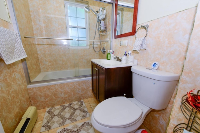 full bathroom with enclosed tub / shower combo, a baseboard heating unit, vanity, tile patterned floors, and toilet