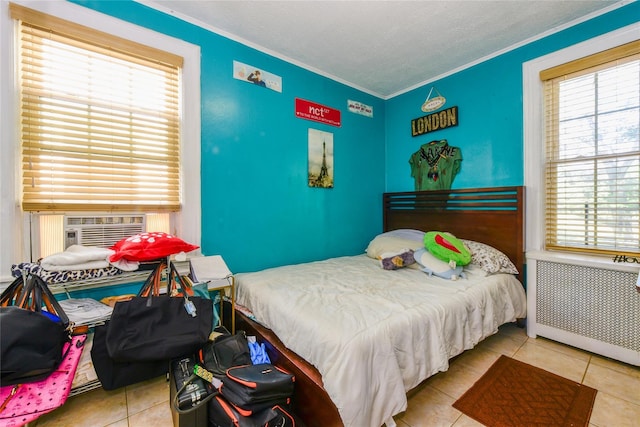 tiled bedroom with ornamental molding and radiator heating unit