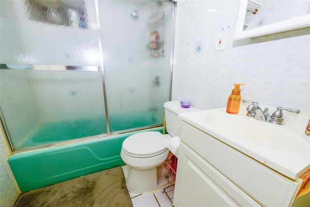 full bathroom featuring tile walls, vanity, toilet, and combined bath / shower with glass door