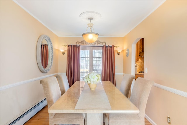 dining area featuring a baseboard radiator and light hardwood / wood-style floors