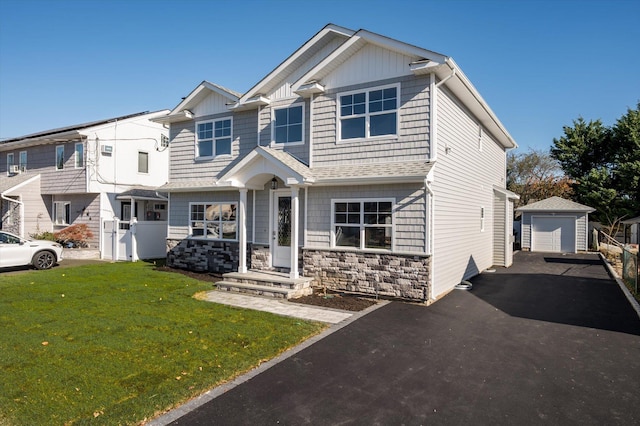 view of front facade with a garage, a front lawn, and an outdoor structure