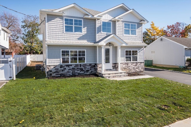 view of front of home with central AC and a front lawn