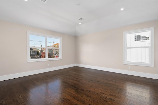 empty room with dark hardwood / wood-style floors and lofted ceiling