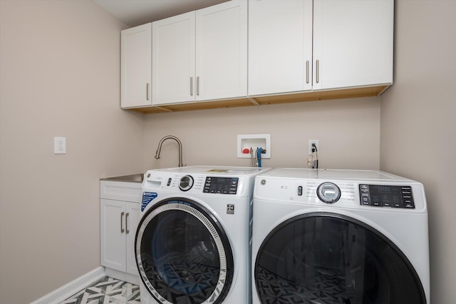 clothes washing area featuring cabinets and washer and dryer