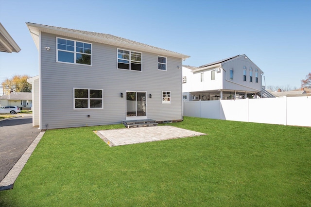 back of property with a lawn and a patio