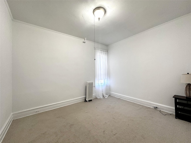 spare room featuring ornamental molding, carpet flooring, and radiator heating unit