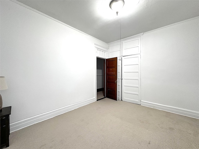 unfurnished bedroom featuring crown molding, light colored carpet, and a closet