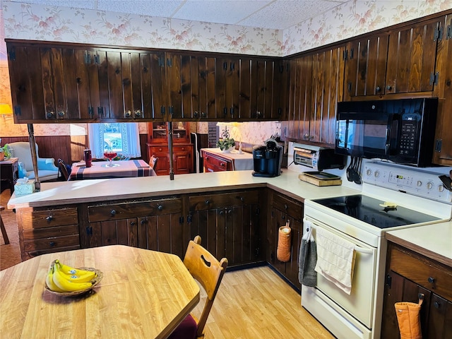 kitchen with dark brown cabinets, white electric stove, light hardwood / wood-style flooring, and kitchen peninsula