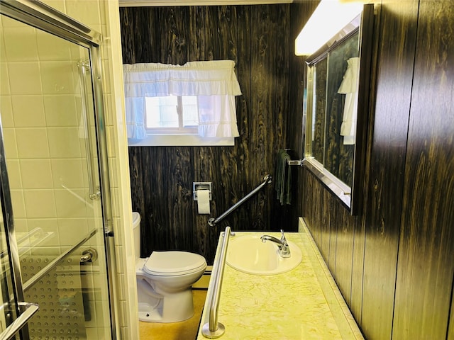 bathroom featuring toilet, vanity, and wooden walls