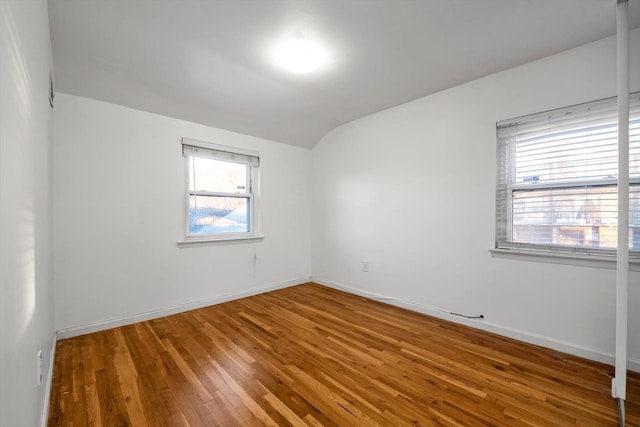 spare room with lofted ceiling and hardwood / wood-style floors