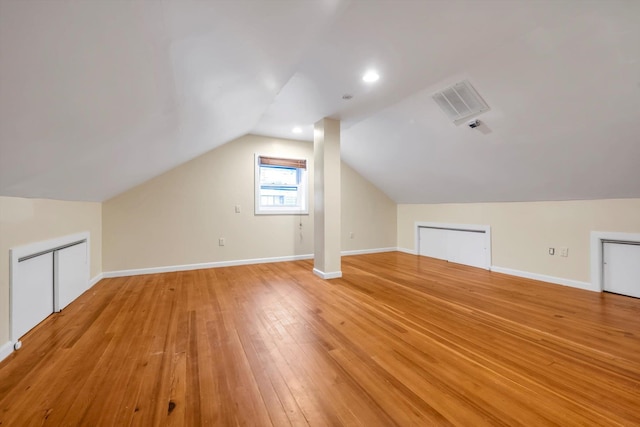 additional living space with vaulted ceiling and light wood-type flooring