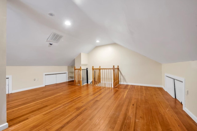 bonus room featuring lofted ceiling and light hardwood / wood-style flooring