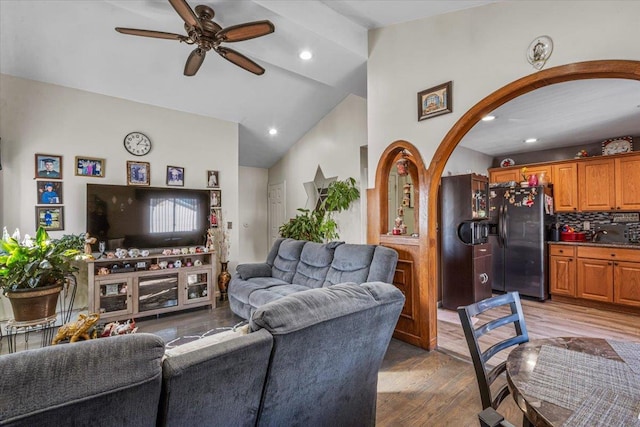 living room featuring high vaulted ceiling, light hardwood / wood-style floors, and ceiling fan