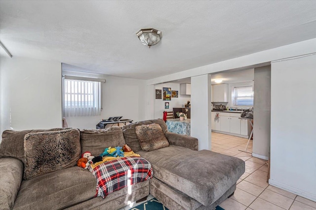 living room featuring sink, a textured ceiling, a healthy amount of sunlight, and light tile patterned flooring