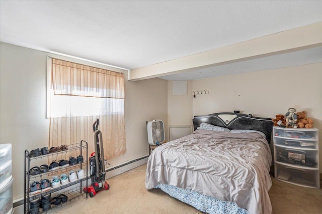 carpeted bedroom featuring beam ceiling and baseboard heating