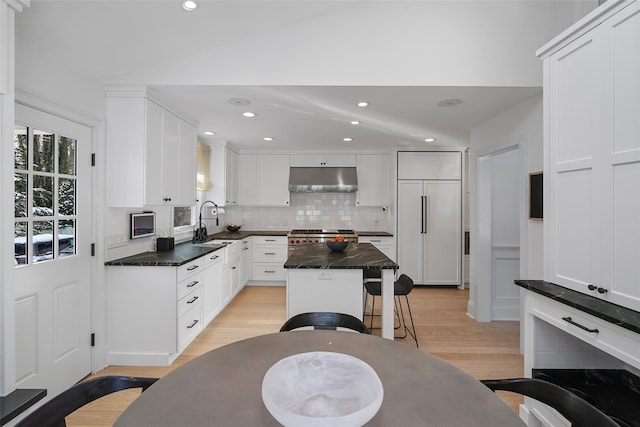 kitchen featuring white cabinetry, light hardwood / wood-style floors, a center island, and sink