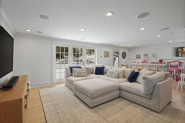 living room with ornamental molding and light hardwood / wood-style floors