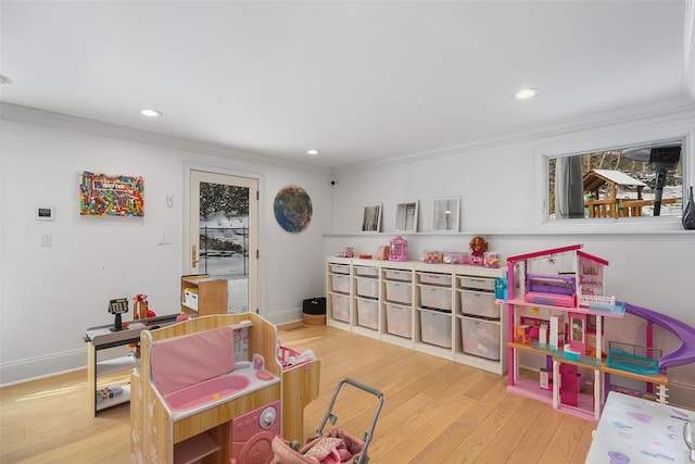 recreation room with light hardwood / wood-style flooring and ornamental molding