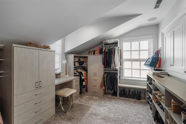 spacious closet with lofted ceiling and dark carpet