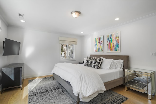 bedroom with crown molding and hardwood / wood-style floors