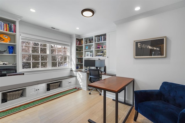 home office with ornamental molding and light hardwood / wood-style floors