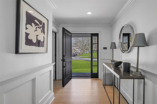 entrance foyer featuring crown molding and light wood-type flooring