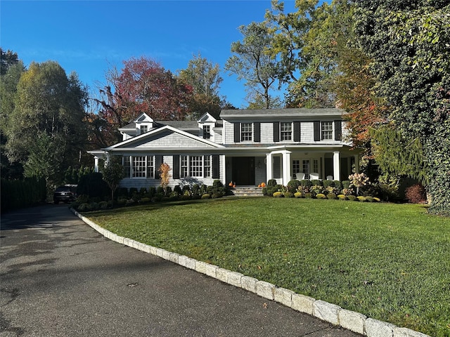 colonial inspired home with a front lawn and a porch