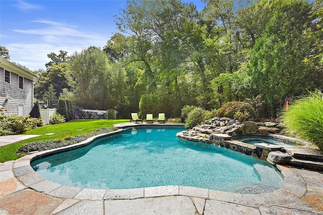 view of swimming pool with an in ground hot tub and a yard