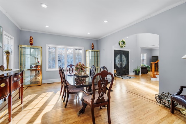 dining space featuring ornamental molding and light wood-type flooring